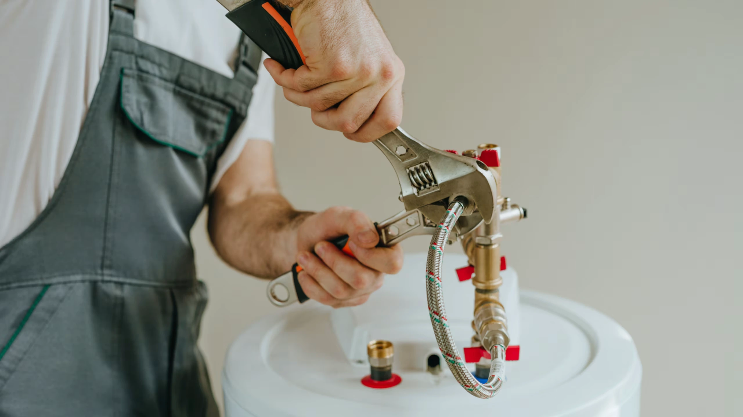 A plumber performs routine maintenance on a home water heater. 